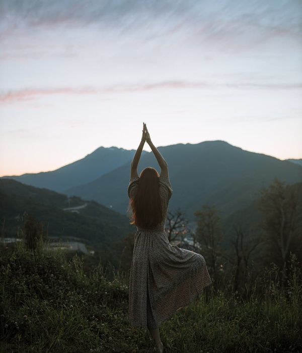 Woman performing a gentle stretching exercise in a calm environment.
